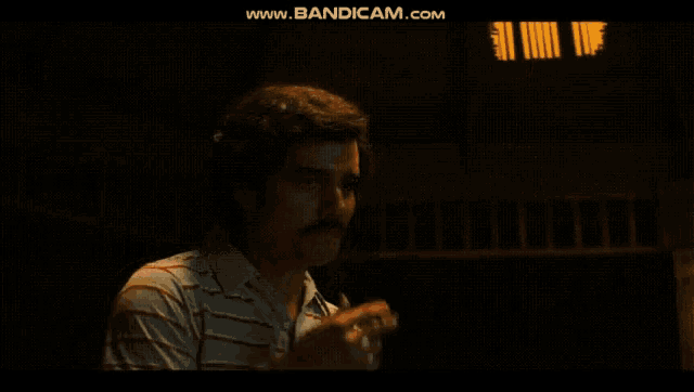 a man in a striped shirt is smoking a cigarette with the website www.bandicam.com in the corner
