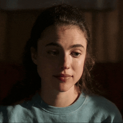a close up of a woman 's face wearing a blue sweater