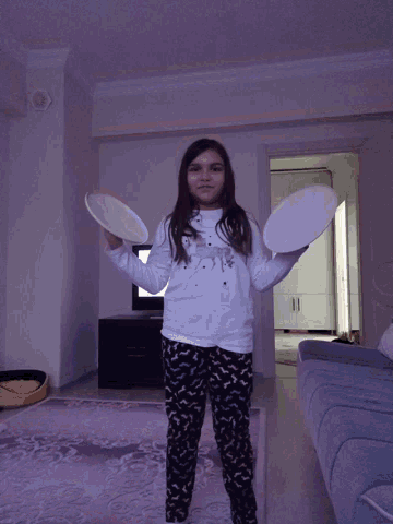 a girl wearing a white shirt that says ' i love you ' on it is throwing plates in the air
