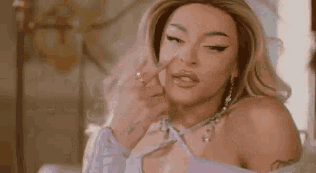 a woman in a wig is applying makeup to her face .