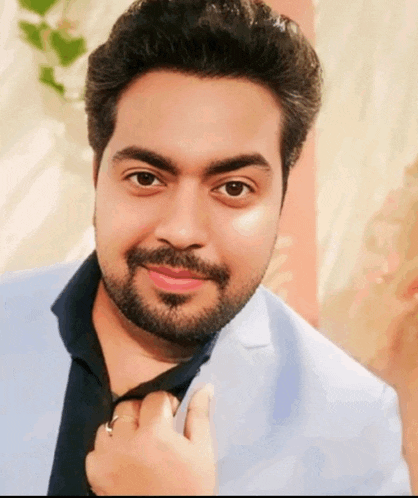 a man with a beard is wearing a blue jacket and a black shirt