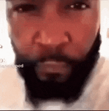a close up of a man 's face with a beard and nose ring .