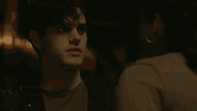 a man with curly hair is looking at a woman