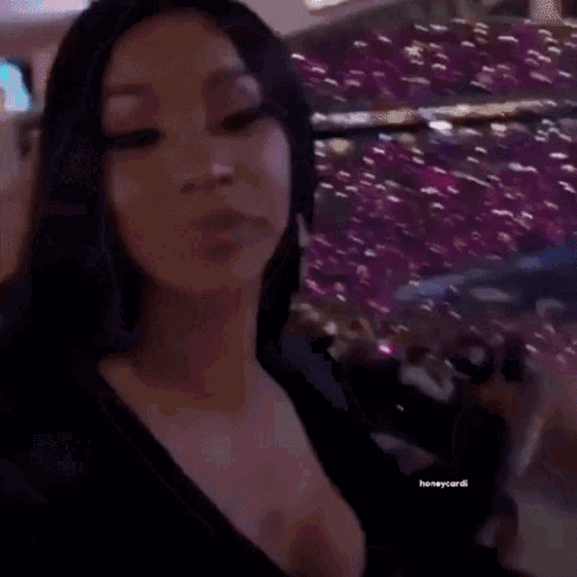 a woman is dancing in a club in front of a crowd of people .