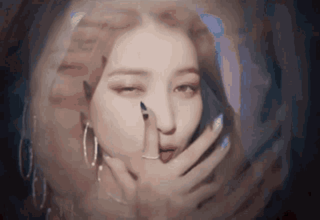 a close up of a woman covering her mouth with her hands