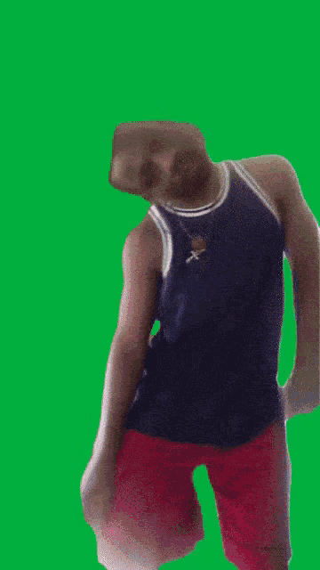a man in red shorts and a blue tank top is dancing on a green screen