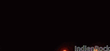 a close up of a person 's face with fire coming out of it and the words indian rock on the bottom