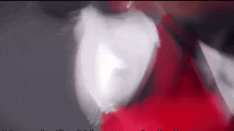 a close up of a person holding a red and white object .