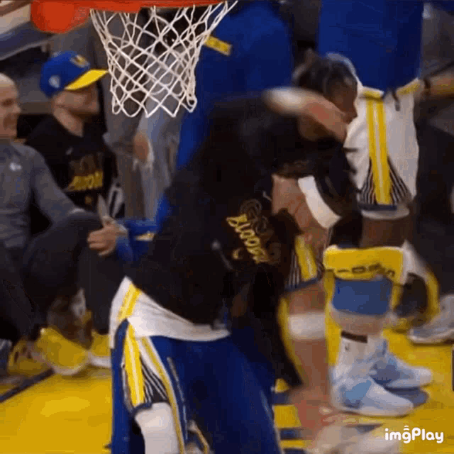 a basketball player wearing a golden state warriors shirt is getting ready to dunk