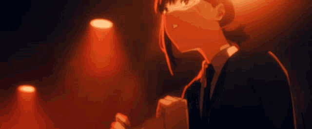 two people are standing in a dark room in front of a red light