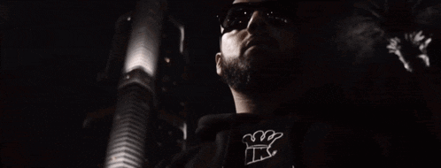 a man with a beard wearing sunglasses and a t-shirt that says ts