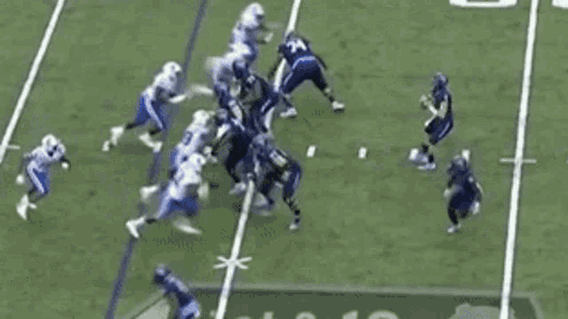a group of football players are playing a game on a field with the number 10 on the sidelines .