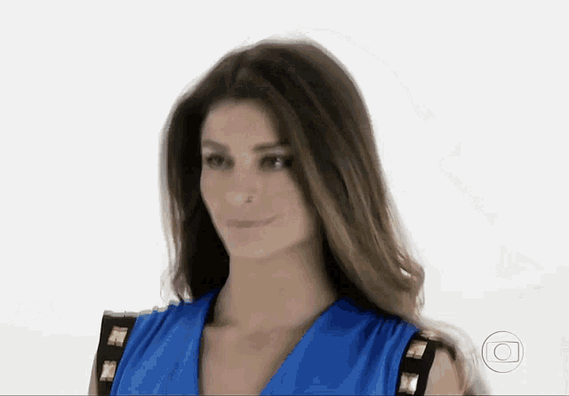 a woman is wearing a blue dress with gold studs