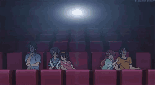 a group of people are sitting in a theater watching a movie .