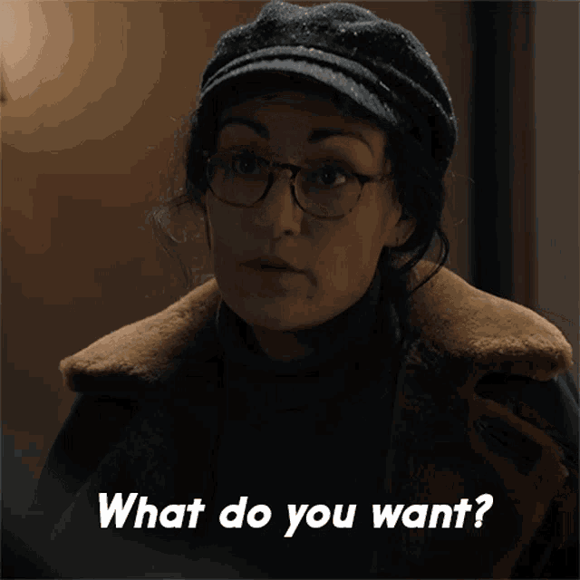 a woman wearing glasses and a hat says " what do you want "