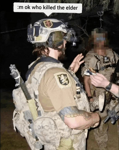 a soldier with a k3 patch on his helmet is talking to another soldier
