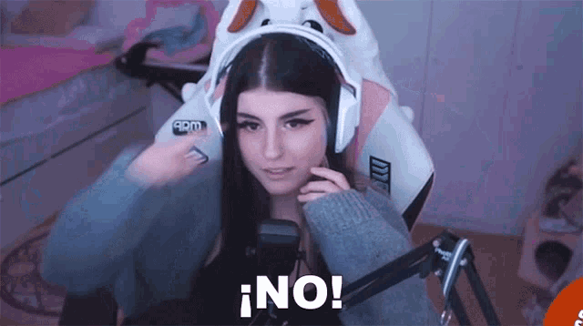 a girl wearing headphones and a bunny hat says no