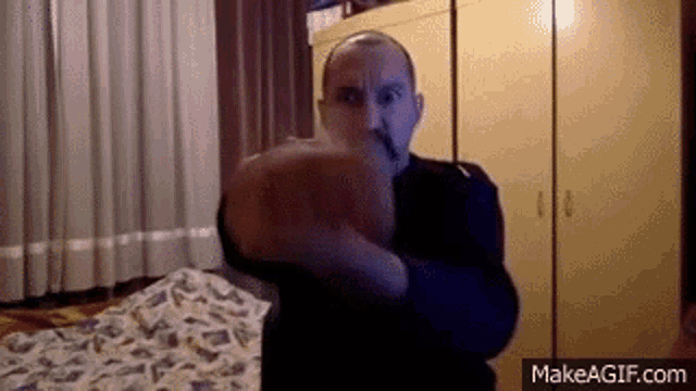 a man is throwing a fist in the air in a room .