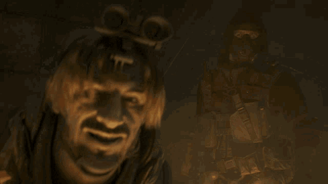 a man with a t on his head looks at the camera