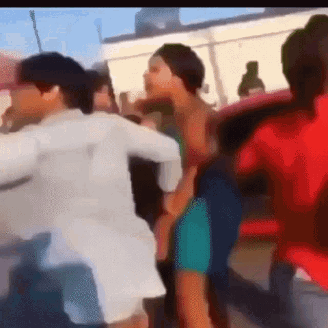 a group of people are dancing in front of a building in a blurry video .