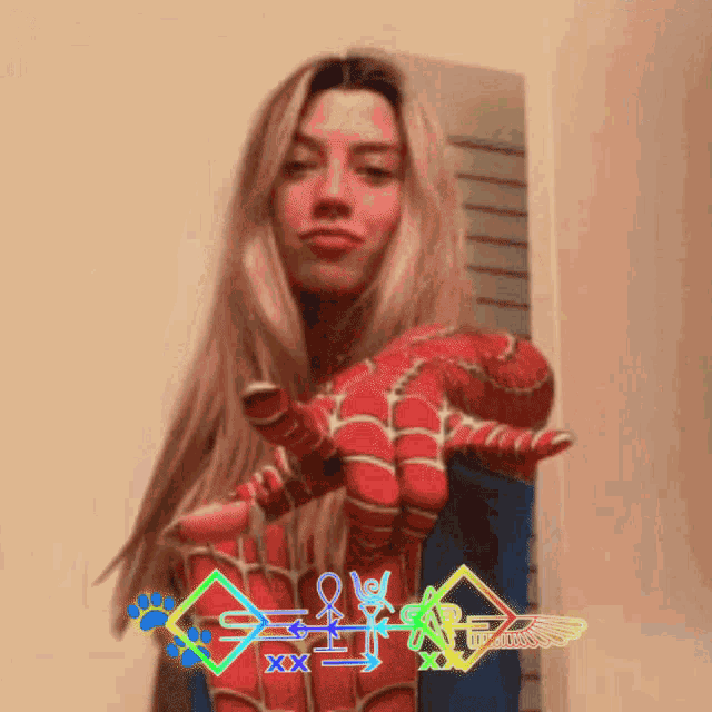 a woman in a spiderman costume is holding up her hand
