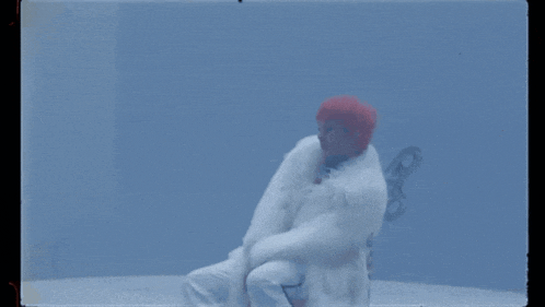 a person in a white fur coat is laying down