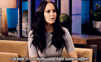 a woman sitting on a couch talking about drinking 3 red bulls and had some coffee