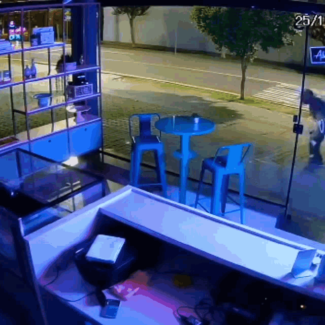 a man is walking down the street in front of a store with the date 25/11