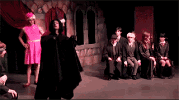 a woman in a pink dress is standing in front of a group of people dressed as harry potter characters
