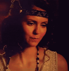 a woman wearing a headband and a pearl necklace