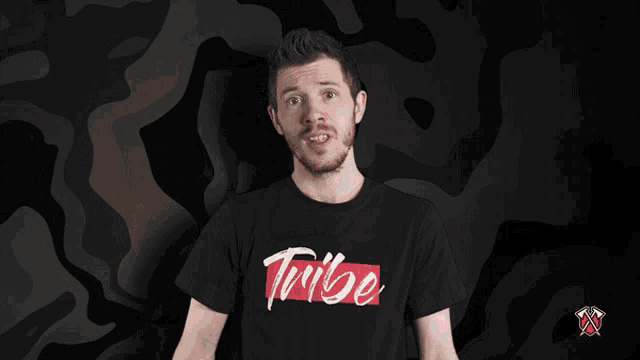 a man wearing a black t-shirt that says tribe on it