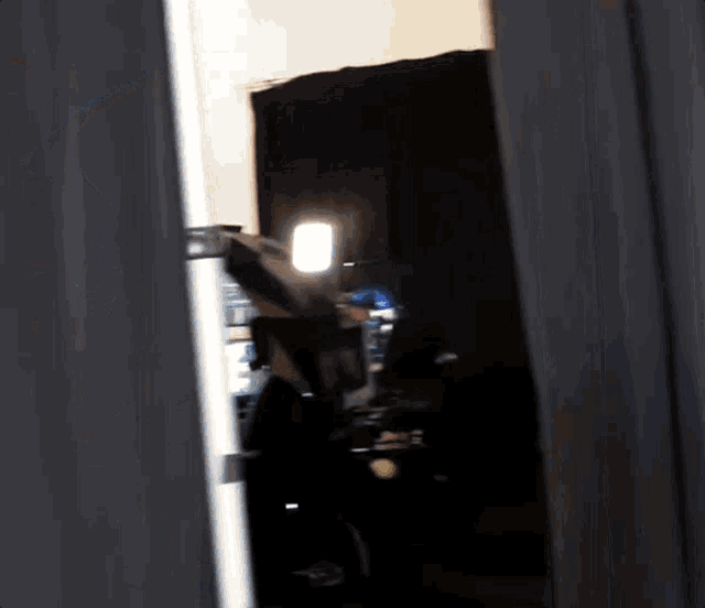 a person is standing in a dark room with a light shining on them