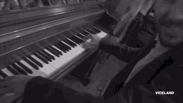 a black and white photo of a man playing a piano with the word viceland on the bottom right