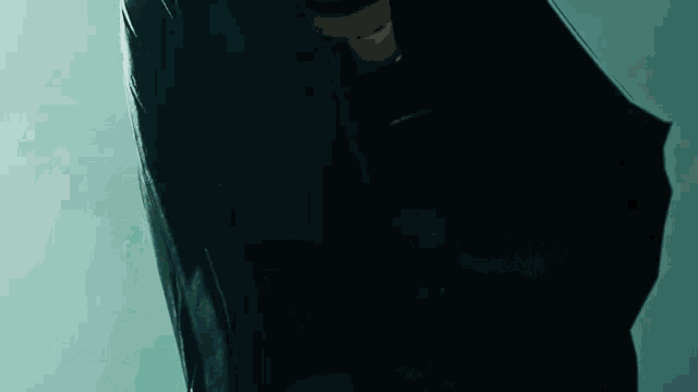a close up of a person wearing a black jacket and glasses