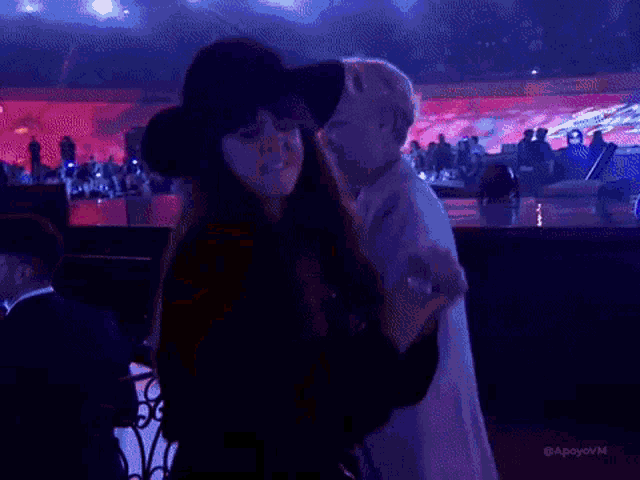 a woman wearing a black hat is dancing in a dark room ..