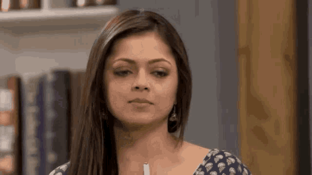 a woman is making a funny face while holding a pen in her hand .
