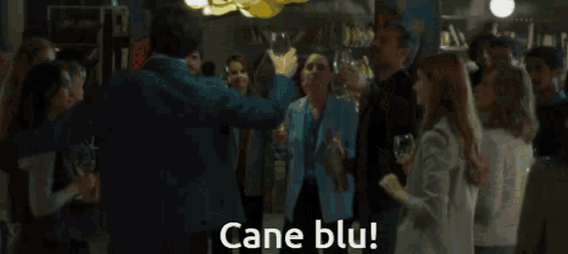a man in a suit is holding a glass of wine and says cane blu