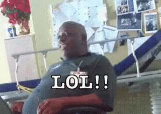 a man is sitting in a hospital bed with the words lol written on his face .