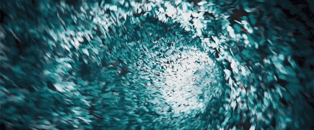 a painting of a blue and white swirl with a light at the end .