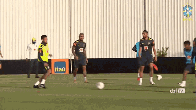 a group of soccer players are practicing on a field with an advertisement for itaú in the background