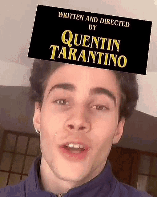 a young man is wearing a quentin tarantino sticker on his head