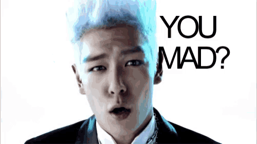a man with white hair is making a funny face in front of a sign that says you mad