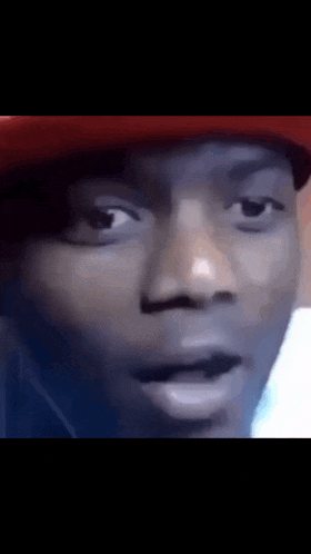 a close up of a man 's face wearing a red hat