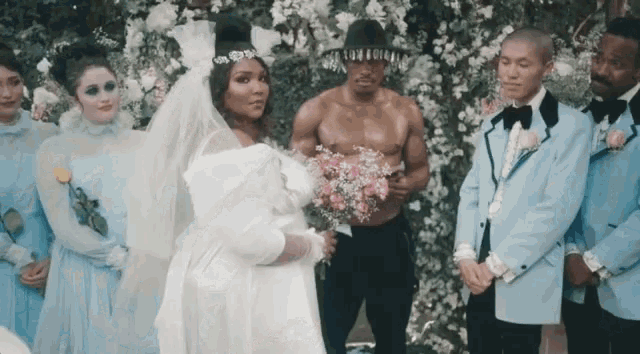a bride and groom are surrounded by their wedding party in blue suits