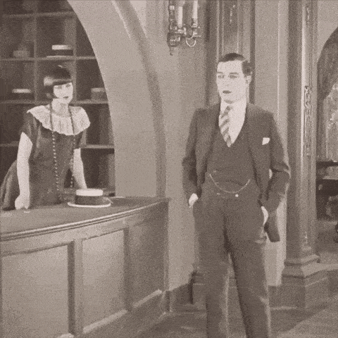 a man in a suit and tie stands in front of a woman