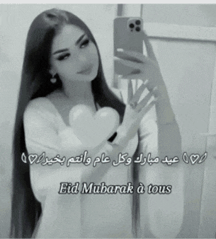 a black and white photo of a woman taking a selfie with the words eid mubarak à tous