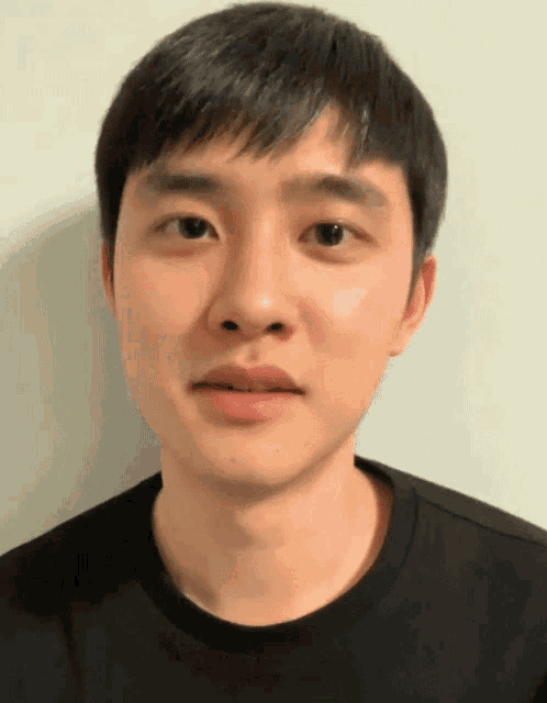 a close up of a young man 's face with a black shirt on