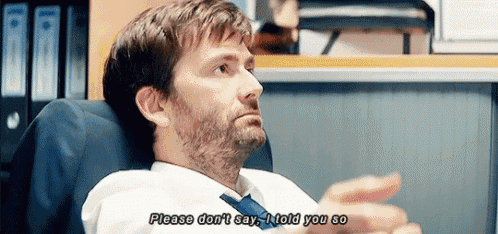 a man in a suit and tie is sitting in an office and saying please don 't say i told you so