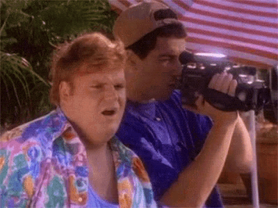 two men are standing next to each other and one is holding a camera .