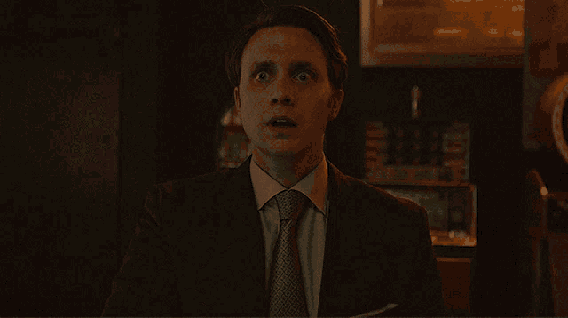 a man in a suit and tie with his mouth open